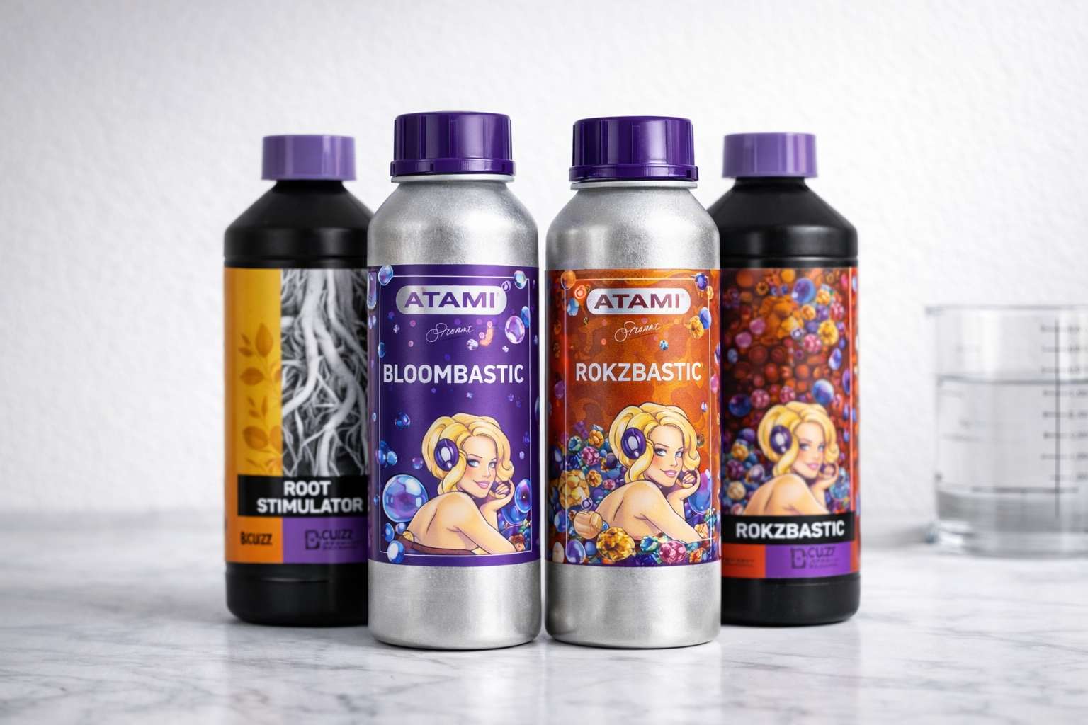 Bloombastic y Rokzbastic de Atami B’Cuzz junto a botellas de Root Stimulator sobre fondo claro tipo estudio