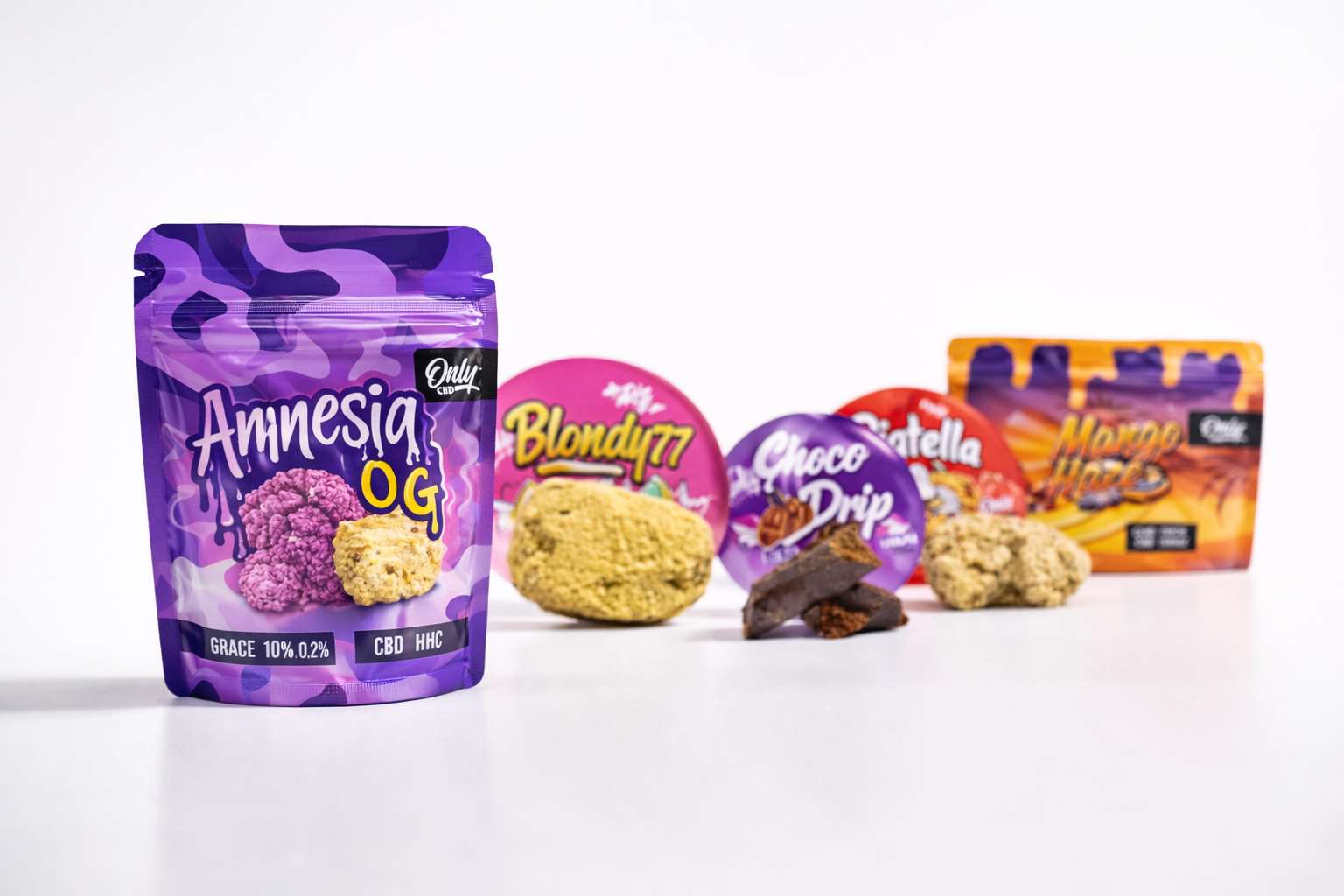 Bolsa morada Amnesia OG de Only CBD en primer plano con varios productos y piezas de resina desenfocadas al fondo